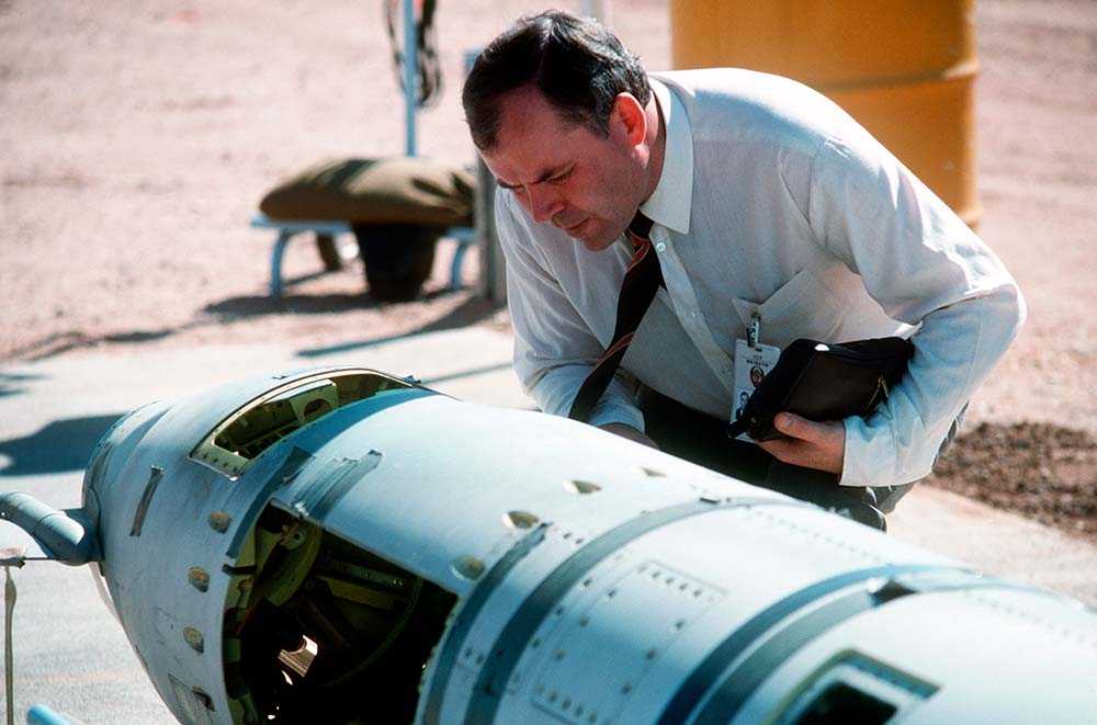 An inspector inspects a ground launched cruise missile with a concentrated face.